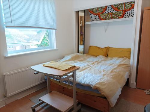 a small bedroom with a bed and a table at UnknownRooms in London