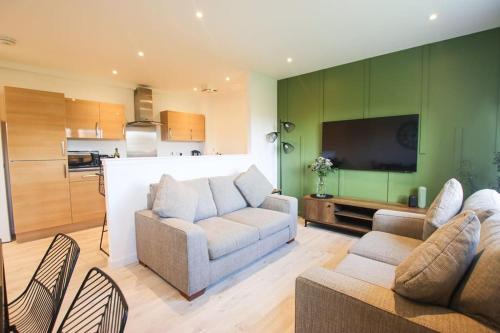 a living room with two couches and a flat screen tv at City Hub by the Castle Free Designated Parking in Stirling