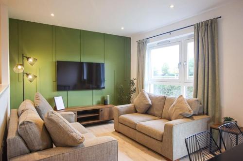 a living room with two couches and a flat screen tv at City Hub by the Castle Free Designated Parking in Stirling