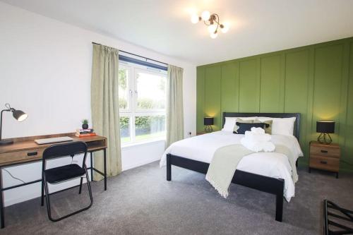 a bedroom with a bed and a desk and a window at City Apartment by the Castle, Free Parking. in Stirling