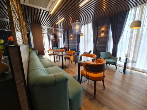 a lobby with a couch and tables and chairs at Hotel Fogo Amsterdam in Amsterdam
