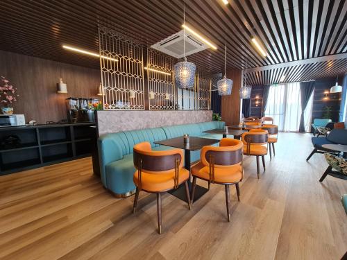 a restaurant with a blue couch and orange chairs at Hotel Fogo Amsterdam in Amsterdam