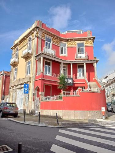 a red building on the corner of a street at OLOPO Hostel in Porto