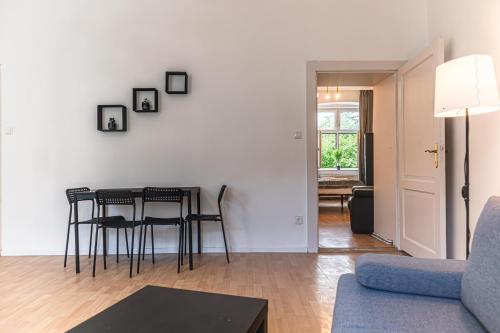 a living room with a table and chairs and a couch at Pleasant 2BR Apt- Near Train Station Hetzendorf in Vienna