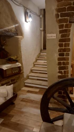 una scala in una stanza con un muro di mattoni di Un Tuffo nel passato "B&B Santu Giuvanni" a Fonni
