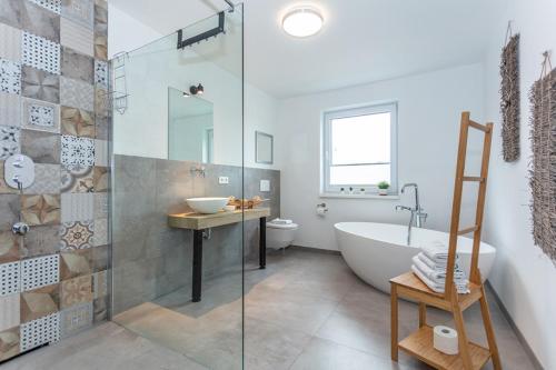 a bathroom with a tub and a toilet and a sink at Boardinghouse in Bad Reichenhall