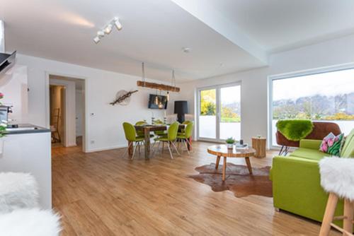 a living room with a green couch and a table at Boardinghouse in Bad Reichenhall