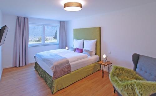 a bedroom with a large bed and a chair at Boardinghouse in Bad Reichenhall