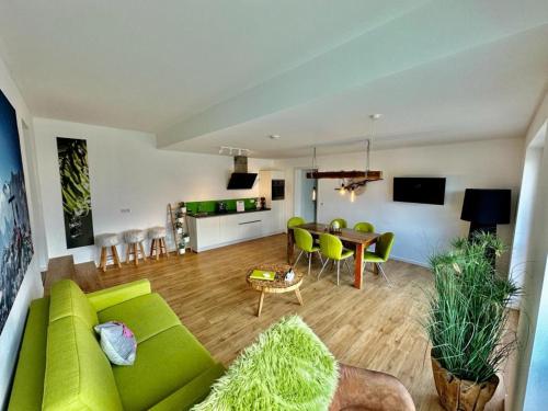 a living room with a green couch and a table at Boardinghouse in Bad Reichenhall