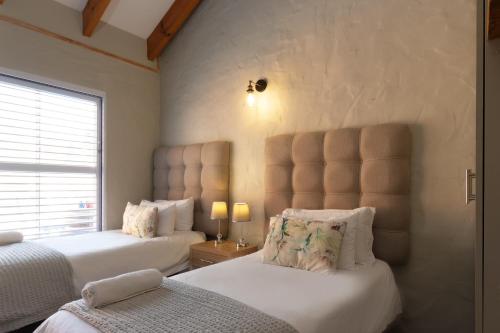 a bedroom with two beds and a window at Owls Nest Self Catering in George