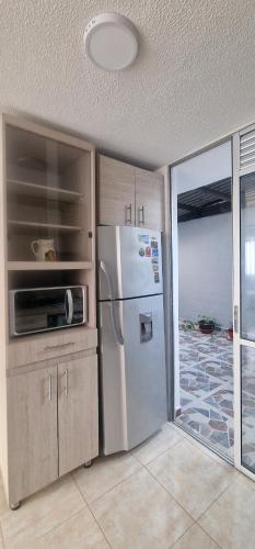 a kitchen with a refrigerator and a sliding glass door at Despertar Cafetero in Dosquebradas
