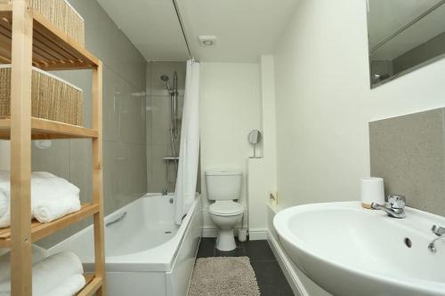 a bathroom with a toilet and a tub and a sink at Apartment in the heart of Cheltenham/ Parking in Cheltenham