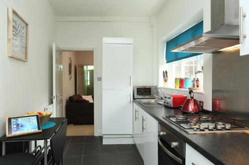 a kitchen with a stove and a counter top at Apartment in the heart of Cheltenham/ Parking in Cheltenham