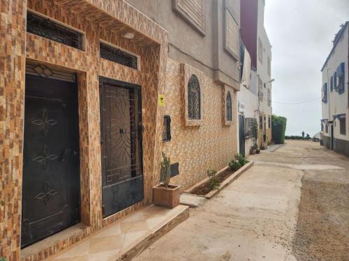 um edifício de tijolos com duas portas numa rua em Winou Surf House em Aourir