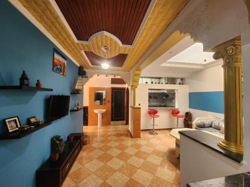 un soggiorno con pareti blu e soffitto in legno di Winou Surf House ad Aourir