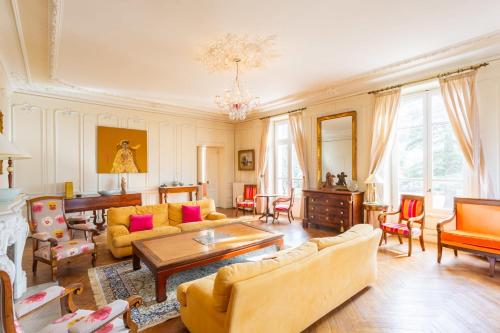 un salon rempli de meubles et d'un lustre dans l'établissement Domaine des sources - Welkeys, à Orange