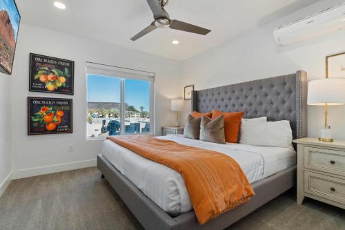a bedroom with a large bed with an orange blanket at 20| Vue at Green Valley with Community Pool in St. George