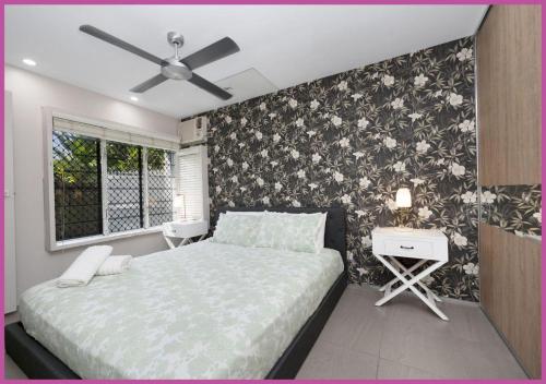 Aitkenvale的住宿－Sturges Street 22 - Unit 2，一间卧室设有一张床和花卉装饰的墙壁