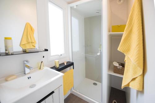 a bathroom with a white sink and a shower at CAMPING PLEIN SOLEIL in Lourdes