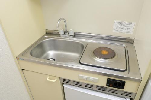 a sink in a small kitchen with a sink at メゾンファミール成瀬 in Machida