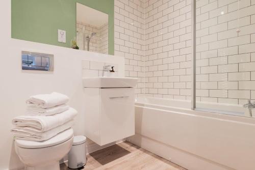 a bathroom with a toilet and a sink and a tub at StayZeni, Hardwick House Derby Lovely 1 Bed Flat in Derby