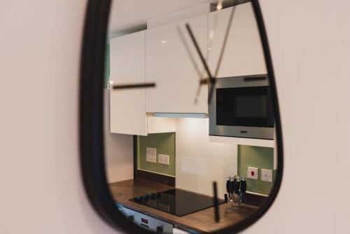 a mirror reflection of a kitchen with a stove and cabinets at Modern 1 Bed Apartment, Nightingale Quarter Derby in Derby