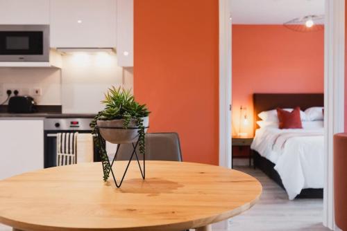 una mesa con una maceta en una habitación en Modern 2 Bed Apartment, Nightingale Quarter Derby, en Derby