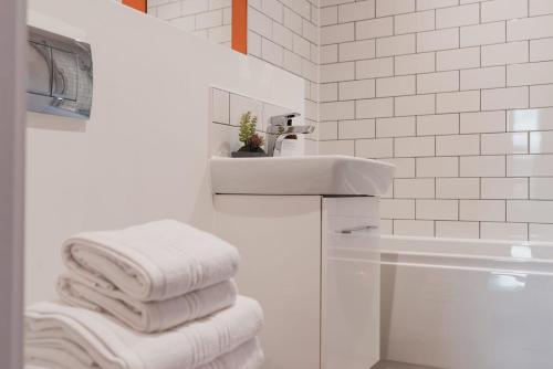 Baño blanco con lavabo y toallas en Modern 2 Bed Apartment, Nightingale Quarter Derby, en Derby