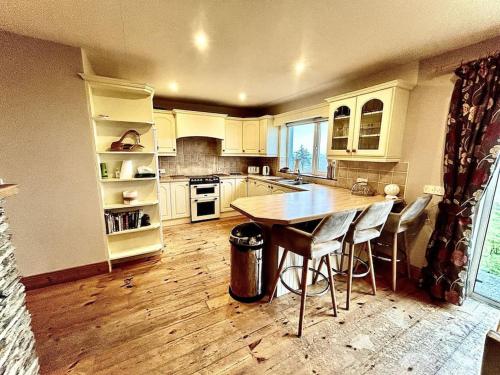 eine Küche mit einem Tisch und Stühlen in der Unterkunft Ballinskelligs Coastal Sanctuary in Ballinskelligs