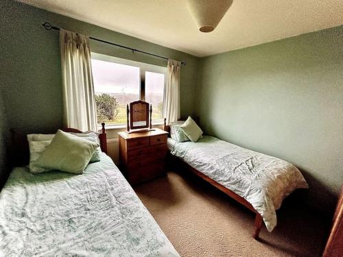 1 Schlafzimmer mit 2 Betten und einem Fenster in der Unterkunft Ballinskelligs Coastal Sanctuary in Ballinskelligs