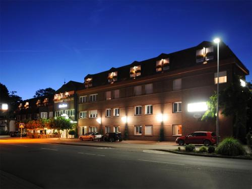 a building with cars parked in front of it at night at Hotel-Restaurant Thomsen in Delmenhorst