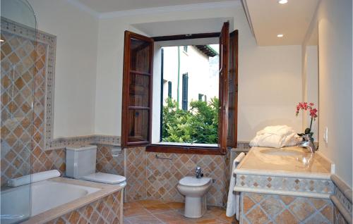 La salle de bains est pourvue d'une baignoire, de toilettes et d'une fenêtre. dans l'établissement Awesome Home In Sller With 7 Bedrooms, Wifi And Outdoor Swimming Pool, à Sóller