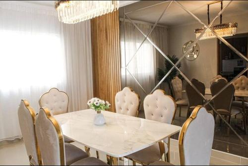 a dining room with a white table and chairs at Confortable Dpto en Residencial in Santo Domingo