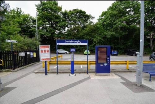 a gas station with two signs in a parking lot at Herbert - Duplex Relocations in Mexborough