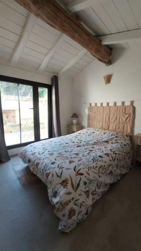 une chambre avec un lit avec une couette et une fenêtre dans l'établissement Mas Anahata - Gîte Shanti, au coeur de la nature, à Générargues