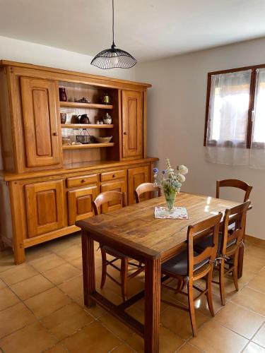 une salle à manger avec une table et des chaises en bois dans l'établissement La maison de Rémi au bord de la Dordogne !, à Flaujagues