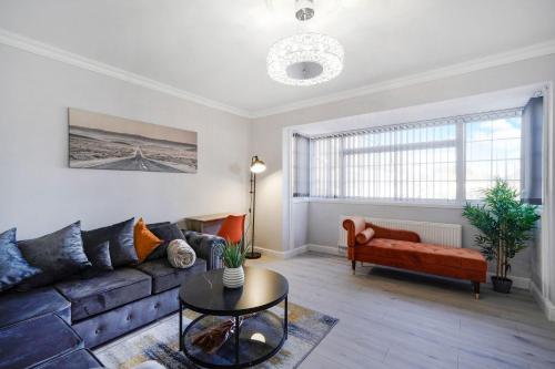 Spacious, 4 bed, Garden, Parking, ExCel London في لندن: غرفة معيشة مع أريكة وطاولة