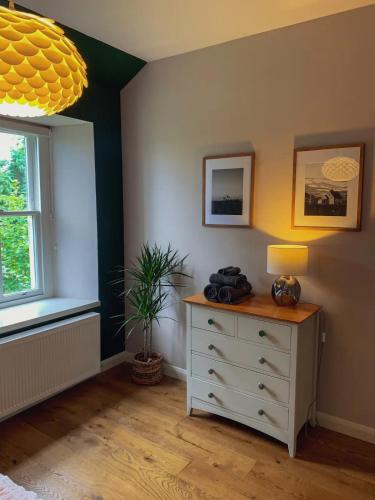 a bedroom with a dresser and a window at Unique Highland in Inverness