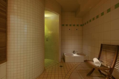 La salle de bains est pourvue d'une douche, d'un lavabo et de toilettes. dans l'établissement IFA Rügen Hotel & Ferienpark, à Binz