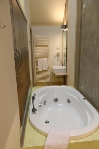 uma grande banheira branca numa casa de banho com lavatório em Borgo Santa Giulia em Corte Franca