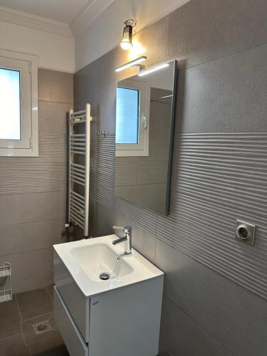 La salle de bains est pourvue d'un lavabo et d'un miroir. dans l'établissement Seaside Luxury Apartments, à Pórto Ráfti