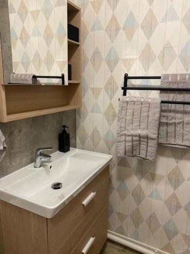 une salle de bain avec un lavabo et un miroir dans l'établissement Le Cocon, à Cherbourg en Cotentin