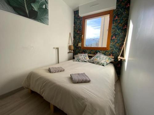 une chambre avec un lit avec deux oreillers dessus dans l'établissement Le Cocon, à Cherbourg en Cotentin