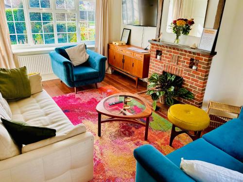 a living room with a couch and a table at Cooden Cottage in Bexhill