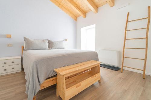 a white bedroom with a bed and a ladder at B&B La Volpe in Moneglia