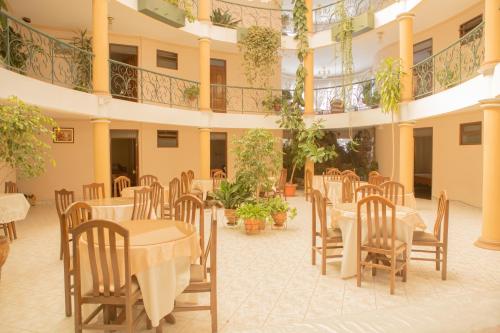 a restaurant with tables and chairs in a building at Hostal España in Sucre