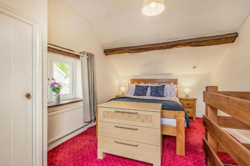 a bedroom with a bed and a window at Bluebell Cottage in Ross on Wye