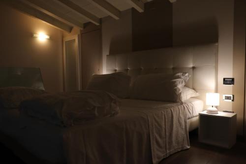 a bed in a dark room with a lamp at Borgo Santa Giulia in Corte Franca