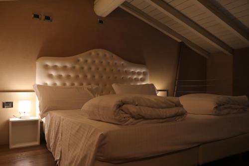 a bedroom with a large bed with a white headboard at Borgo Santa Giulia in Corte Franca