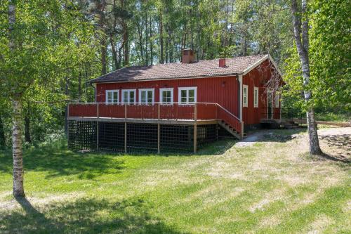 une maison rouge au milieu d'une forêt dans l'établissement Bergs Gård & Hållsvikens Gård, à Västerljung
